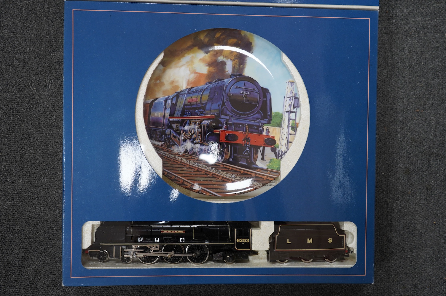 Four boxed Hornby Railways 00 gauge train packs in collaboration with Royal Doulton; an LMS Coronation Class locomotive (R459), an SR Schools Class locomotive (R648), and two GWR King Class locomotives (R650). Condition